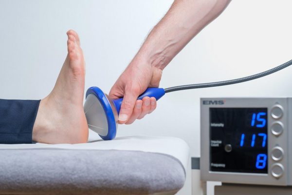 Ein Fuß wird mit Stoßwellentherapie behandelt